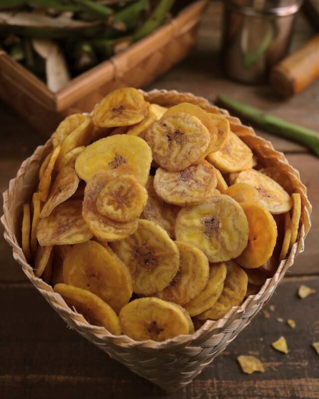 Delicious crispy banana chips in a rustic woven basket, perfect snack for any occasion.
